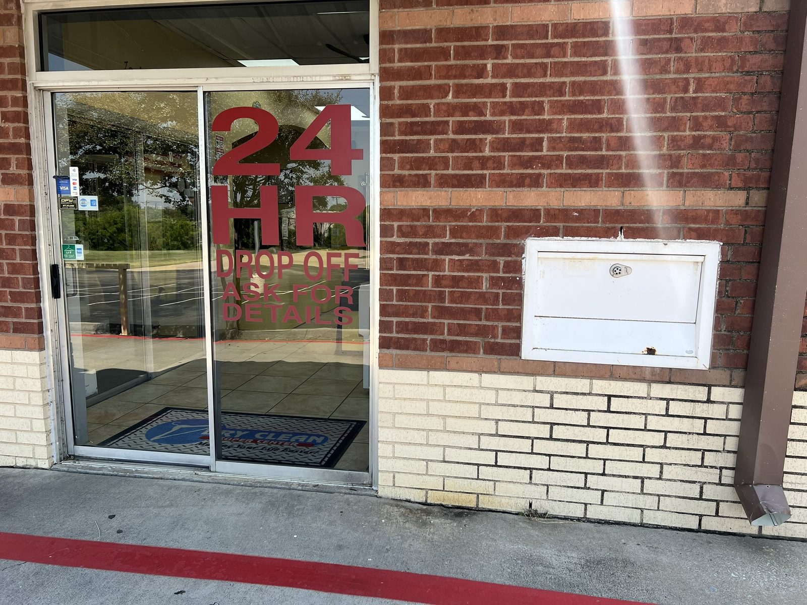 The 24-hour drop-off box mounted on the wall beside the drive-thru door